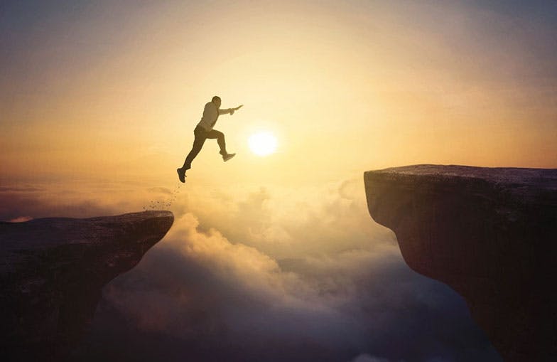 Picture of man jumping across two rocks